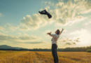 A man in a white shirt and tie throwing his suit jacket into the air in a golden field at sunset, symbolizing freedom, joy, and the power of rejoicing.