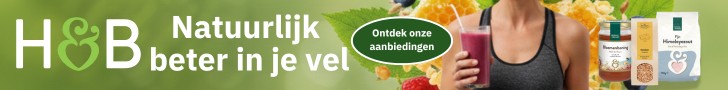 Holland & Barrett advertentie: Natuurlijk beter in je vel. Vrouw met smoothie en vers fruit op een groene natuurlijke achtergrond.