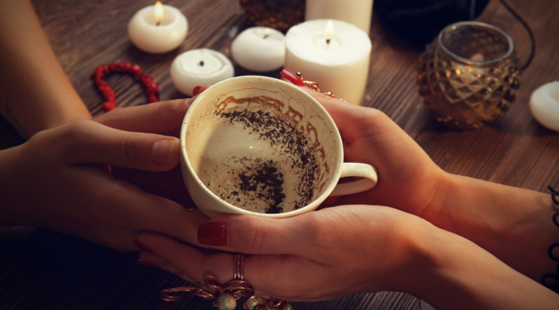 Hands swirling a teacup to settle the leaves for a tasseomancy reading.