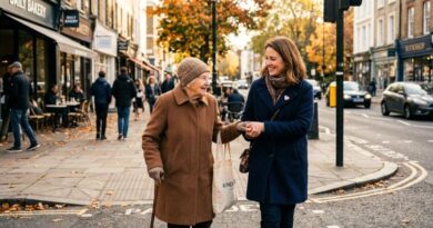 A smiling young woman kindly assisting an elderly lady while crossing a street in a warm, sunny neighborhood, illustrating a small act of kindness and the ripple effect of compassion.