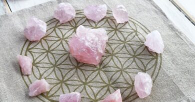 Rozenkwarts edelstenen in een cirkel op een Flower of Life onderzetter voor spirituele groei en zelfliefde.