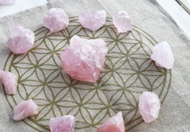 Rozenkwarts edelstenen in een cirkel op een Flower of Life onderzetter voor spirituele groei en zelfliefde.
