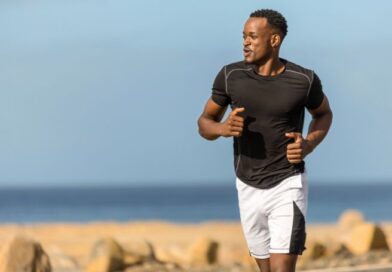 Een hardloper in sportkleding rent in een rustig tempo langs het water tijdens een herstelloop