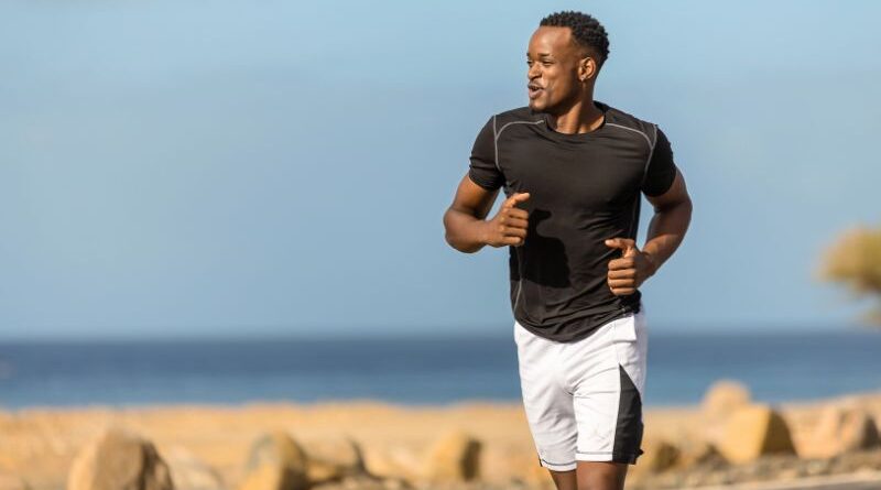 Een hardloper in sportkleding rent in een rustig tempo langs het water tijdens een herstelloop