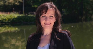 Portret van de Nederlands-Hongaarse componiste Kerani, die glimlachend buiten poseert bij het water