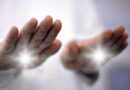 Close-up of a practitioner's hands projecting bright white light during a non-invasive pranic healing energy work session.