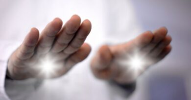 Close-up of a practitioner's hands projecting bright white light during a non-invasive pranic healing energy work session.