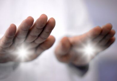 Close-up of a practitioner's hands projecting bright white light during a non-invasive pranic healing energy work session.