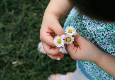Een kind houdt een bosje witte madeliefjes vast als symbool voor onschuld en een nieuw